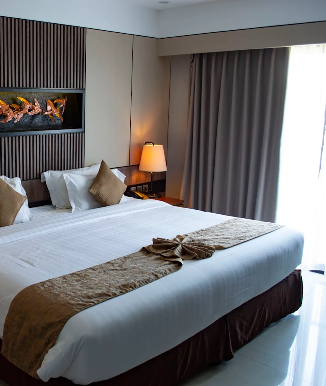 Elegante Suite mit Sofa, warmem Licht und großen Fenstern